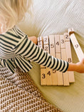 Load image into Gallery viewer, Child playing with wooden number blocks horizontally on bed