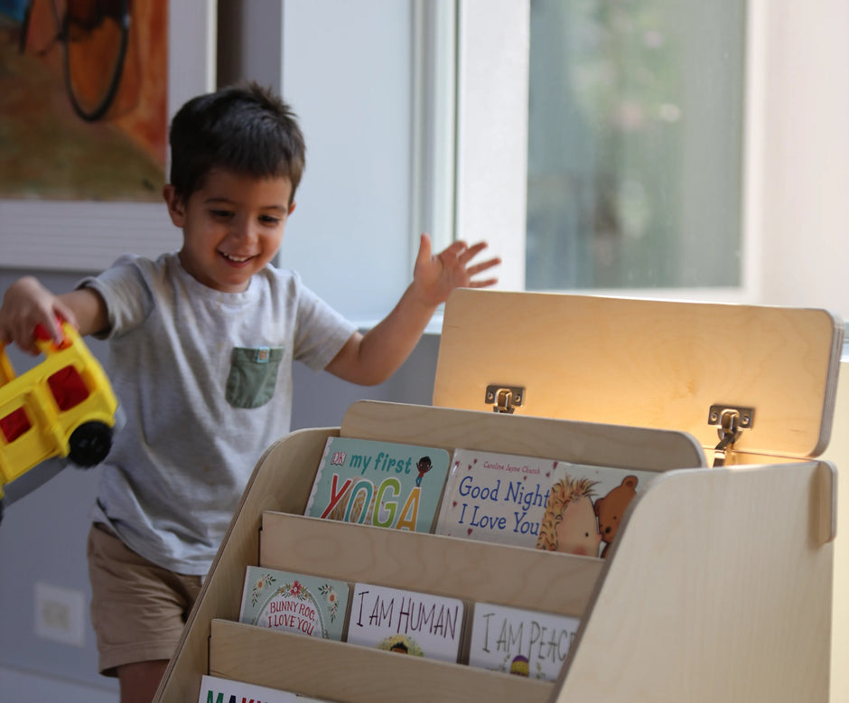 boy playing with toys next to the montessori bookshelf
