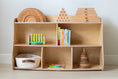 Load image into Gallery viewer, Montessori toy shelf organized with books, stacking rings, abacus, and a woven basket