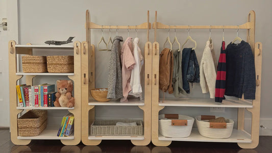 A Montessori children's wardrobe set with hanging clothes, organizational baskets, and books/toys.