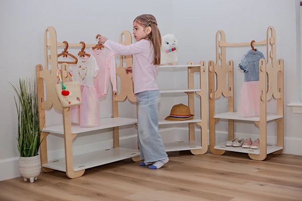 little girl picking her outfit from a montessori clothing rack