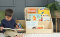 Load image into Gallery viewer, little boy reading in front of a montessori bookshelf
