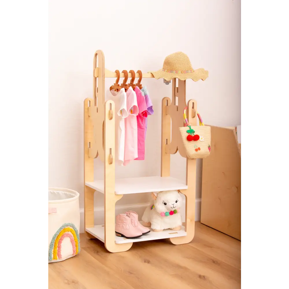 Handmade wooden clothing rack for children's room, with colorful hanging clothes, straw hat, woven basket, plush toy, and boots on display for a cozy nursery decor.