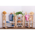 Load image into Gallery viewer, A charming display of children's wooden furniture set against a white wall, featuring two clothes racks with a selection of small, neatly hung garments including a striped shirt and a pink tunic, each rack adorned with a straw hat. The central shelving unit is delightfully decorated with a lush green plant, a wooden rainbow toy, and small potted succulents, with shoes and a plush toy on the lower shelves, creating an organized and playful space.
