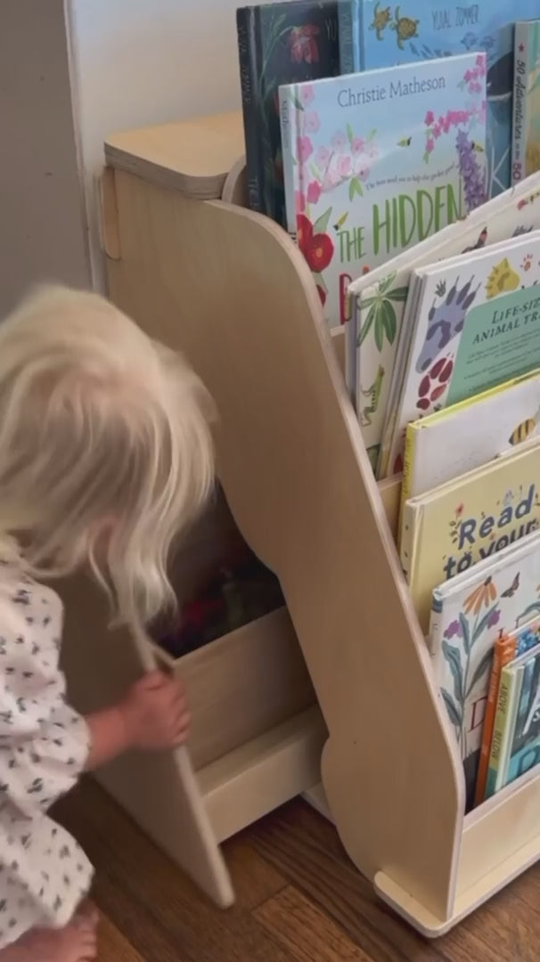kid getting his books from montessori bookshelf with hidden drawer
